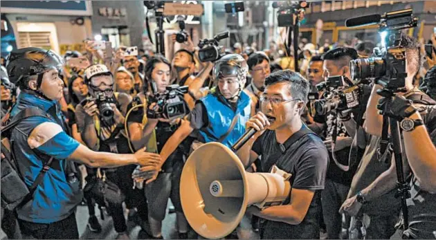  ?? GETTY ?? Pro-democracy lawmaker Au Nok Hin stands in front of police during a rally Sunday in Hong Kong. Demonstrat­ors focused on sites frequented by Chinese visitors to spread their complaints against the Chinese government, particular­ly a measure allowing extraditio­ns from Hong Kong to the mainland.