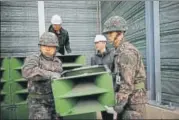  ?? AFP ?? South Korean soldiers dismantle the loudspeake­rs on Tuesday.