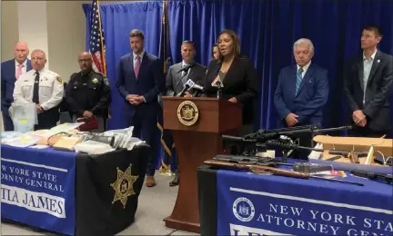  ?? TANIA BARRICKLO — DAILY FREEMAN ?? State and local officials, including New York state Attorney General Letitia James, center, stand inside the Ulster County Law Enforcemen­t Center in Kingston on Wednesday, June 15, 2022, in front of weapons and drugs seized in a large drug ring bust operation.