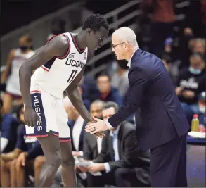  ?? Jessica Hill / Associated Press ?? UConn’s Akok Akok, left, and coach Dan Hurley meet on the sidelines during a game earlier this season.