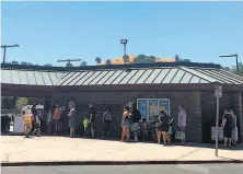  ?? Emma Talley / The Chronicle ?? Swimmers line up in the shade to enter the Walter V. Graham Aquatic Center in Vacaville, where the temperatur­e hit 107.