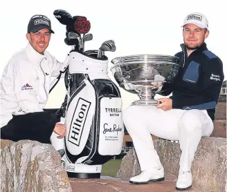  ??  ?? Tyrrell Hatton holds the trophy with his caddie Chris Rice on the Swilken Bridge at St Andrews.