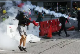  ?? VINCENT THIAN — THE ASSOCIATED PRESS ?? A protester throws back a tear gas canister in Hong Kong on Monday. Droves of protesters filled public parks and squares in several Hong Kong districts on Monday in a general strike staged on a weekday to draw more attention to their demands that the semiautono­mous Chinese city’s leader resign.