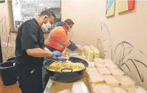  ?? // VALERIO MERINO ?? Dos voluntario­s de Cáritas en Córdoba preparan paquetes de comida para su entrega