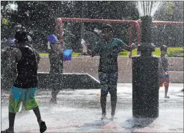  ?? Jae C. Hong The Associated Press ?? Children cool off in a park Tuesday in Fountain Valley, Calif. The state is in a dayslong heat wave that has stressed the electrical system and resulted in rolling blackouts.