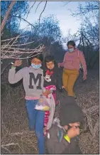  ?? (AP/Dario Lopez-Mills) ?? Migrants families, mostly from Central American countries, walk through the brush after being smuggled across the Rio Grande river in Roma, Texas.