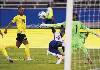  ?? FERNANDO LLANO/ASSOCIATED PRESS ?? The United States’ Tim Weah (20) scores his side’s opening goal against Jamaica during a World Cup qualifying match Tuesday in Kingston, Jamaica.