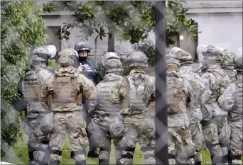  ?? TED S. WARREN — THE ASSOCIATED PRESS ?? A Washington State Patrol trooper talks with members of the Washington National Guard inside a fence surroundin­g the Capitol in anticipati­on of protests Monday, Jan. 11, 2021, in Olympia, Wash. State capitols across the country are under heightened security after the siege of the U.S. Capitol last week.