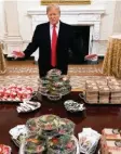  ?? Foto: dpa ?? Ein ganzer Tisch voller Burger und ein stolzer US-Präsident Trump.