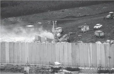  ?? MOHAMMED ZAATARI / THE ASSOCIATED PRESS FILES ?? An Israeli military digger works on the Lebanese-israeli border next to a wall that was built by Israel in the southern village of Kafr Kila, Lebanon, on Dec. 4. The Israeli military had launched an operation to “expose and thwart” tunnels it says were built by the Hezbollah militant group that stretch from Lebanon into northern Israel.