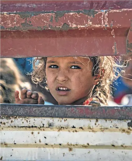  ??  ?? Una niña refugiada siria que huía de la ofensiva turca llega al poblado de Tall Tamr, ayer.