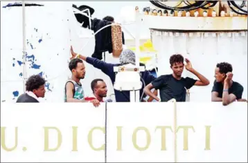  ?? AFP ?? Migrants gather on the deck of the Italian Coast Guard vessel Diciotti in the Sicilian port of Catania on Thursday as they wait to disembark following a rescue operation at sea.