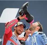  ?? ?? Shoey Enea Bastianini celebra il successo facendo bere al suo capotecnic­o Alberto Giribuola lo spumante dallo stivale, un rito praticato da Ricciardo in F1 (Afp)