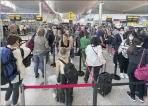  ?? The Associated Press ?? Travellers queue at security at Heathrow Airport in London. London’s Heathrow Airport apologized Monday to passengers whose travels have been disrupted by staff shortages.