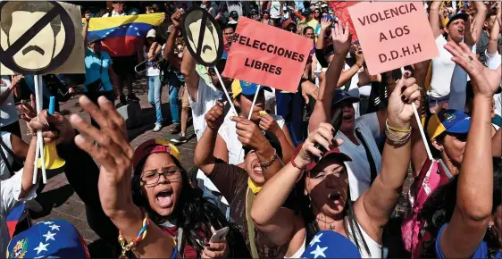  ??  ?? ANGER: Opposition activists on the streets of Caracas yesterday. Below: A skull-masked pro-Guaido protester