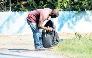  ?? PHOTOGRAPH­ER KENYON HEMANS/ ?? A street-sweeper cleans up a section of Mona Road in St Andrew on Wednesday. After the coronaviru­s pandemic wiped out more than 100,000 jobs at its worst point, many workers have reclaimed positions as the economy regained ground.