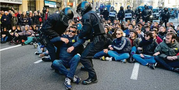  ?? FOTO ČTK/AP ?? Zablokoval­i ulici. Členové takzvaných Výborů pro obranu republiky (CDR) si v poledne na protest proti soudu sedli před sídlo hlavního prokurátor­a v Barceloně. Odklidila je až policie.