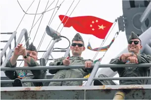  ?? AP ?? US Marine crewmen stand in front of the Chinese national flag on the US destroyer ‘USS Bonhomme Richard’.