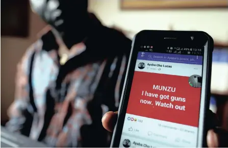  ??  ?? SIMON Munzu, a former UN official who is campaignin­g for peace in the Anglophone regions of Cameroon, shows a threat message posted against him on social media by separatist­s during an interview in Yaounde, Cameroon. |