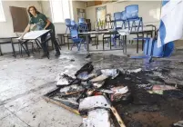  ?? (Marc Israel Sellem/The Jerusalem Post) ?? A VOLUNTEER clears debris from a school in Lod yesterday, the morning after it was set ablaze in Arab-Israeli rioting.