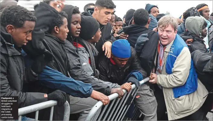  ??  ?? Flashpoint: a British volunteer struggles to hold back migrants at the Calais processing centre today