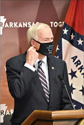  ??  ?? Gov. Asa Hutchinson removes his mask before speaking Thursday, Dec. 3 during a coronaviru­s update at the state Capitol in Little Rock. (Arkansas Democrat-Gazette/ Staci Vandagriff)