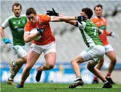  ??  ?? HAND OFF: Armagh’s Charlie Vernon brushes past James McMahon