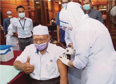  ?? PIC BY NIK ABDULLAH NIK OMAR ?? Kelantan Menteri Besar Datuk Ahmad Yakob receiving the second dose of the Covid-19 vaccine from nurse Suhaila Mansenum in Kota Baru yesterday.
