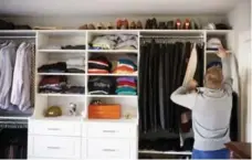  ?? COLE BURSTON FOR THE TORONTO STAR ?? NOW: Mark Diakun reaches for his Blue Jays cap in its spot inside the new closet organized with built-ins that maximize space and storage.