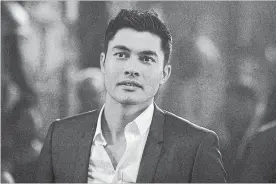  ?? SANJA BUCKO THE ASSOCIATED PRESS ?? Henry Golding in a scene from “Crazy Rich Asians.” In his first movie role, he plays the debonair, Oxford-educated heir Nick Young.