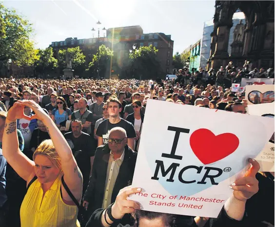  ?? Picture / AP ?? Crowds gather outside Manchester Arena to honour those killed by a bomb blast during an Ariana Grande concert.