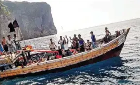  ?? ASSADAWUTH SUDEN/AFP ?? This picture taken with a mobile phone on March 31, shows Rohingya refugees getting drinking water from a Thai fishing boat near Koh Phi Phi Leh, Krabi province of Thailand.