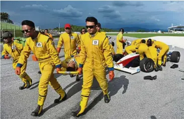  ??  ?? Ready to help: F1 Medical Services Team responding to a simulated race emergency after a press conference for a safety briefing at SIC. — Bernama