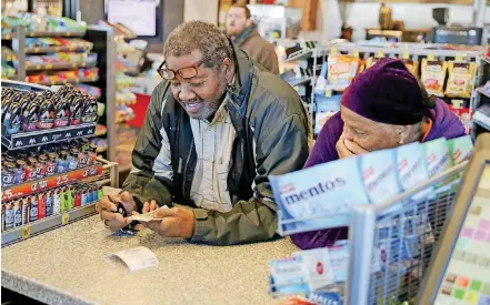  ?? [PHOTOS BY IAN MAULE, TULSA WORLD] ?? Pearlie and Barbra Graves, both of Tulsa, wait for their Powerball tickets after purchasing them at a QuikTrip on Thursday in Tulsa.