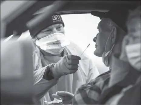  ?? Saed Hindash/ For lehighvall­eylive.com ?? An AMI healthcare worker gives Leroy Kaley, of Shoemakers­ville, a COVID-19 test in Northampto­n County on Dec 2, 2020. Pennsylvan­ia reached 500,000 total coronaviru­s cases on Tuesday, the seventh state to do so, and is near 13,000 deaths.