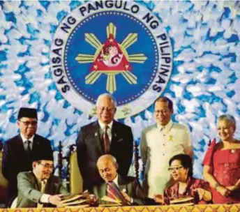  ?? EPA PIC ?? Prime Minister Datuk Seri Najib Razak and then Philippine
President Benigno S. Aquino III (standing, second from right) witnessing the signing of a peace agreement between the Philippine government and the Moro Islamic Liberation Front in Manila in...