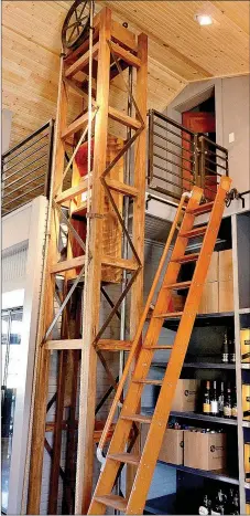  ??  ?? A wooden tower houses an antique pulley and dumb waiter mechanism providing an easy way to lift cases of bottles to the mezannine level. A wooden 1930s ladder provides access to back stock on the upper shelves. See additional photos of the Whistle Stop on page 4B.