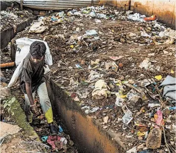  ?? ATUL LOKE/THE NEW YORK TIMES ?? Rahul, 11, searches for plastic to sell to a recycler in Tumakuru in southern India this month.