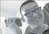  ?? ZHANG NAN / XINHUA ?? A visually impaired teenager listens to music on his cellphone in Changchun, Jilin province.