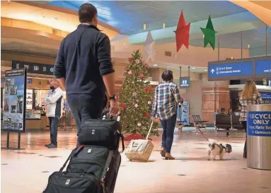  ?? MEG POTTER/THE REPUBLIC FILE ?? Travelers head to their gates in Terminal 4 at Phoenix Sky Harbor Internatio­nal Airport on Dec. 18. At Sky Harbor last year, TSA officials at security checkpoint­s found 124 firearms with passengers or in their bags.