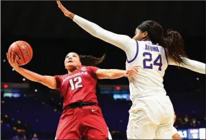  ?? (Photo courtesy LSU Athletics) ?? Destiny Slocum of Arkansas reaches to score past LSU’s Faustine Aifuwa on Sunday in Baton Rouge. Slocum had 29 points as the Razorbacks won 74-64 for their sixth victory in their past seven games. More photos at arkansason­line.com/222ualsu/