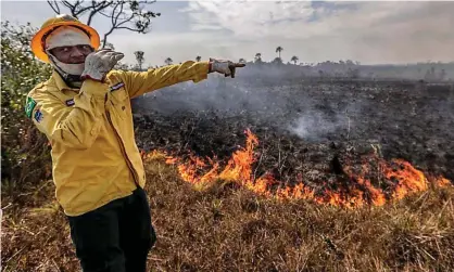  ??  ?? A worker of the Brazilian Institute of the Environmen­t points at the damage caused by a fire in Manicore, Amazonas, Brazil on 26 August 2019. Photograph: AE/Xinhua/Barcroft Media