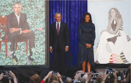  ?? (Jim Bourg/Reuters) ?? FORMER US PRESIDENT Barack Obama and former first lady Michelle Obama stand with their portraits during an unveiling ceremony at the Smithsonia­n’s National Portrait Gallery in Washington Monday.