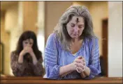  ?? JAY JANNER — AUSTIN AMERICAN-STATESMAN VIA AP, FILE ?? Dorsey Prince, right, and Shannon Carter pray during an Ash Wednesday Mass at St. John Neumann Catholic Church in Austin, Texas, Feb. 22, 2023.