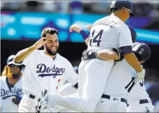  ?? Alex Gallardo ?? The Associated Press Chris Taylor, left, and Kike Hernandez (14) greet Logan Forsythe (11) after his walk-off RBI single in the 10th inning of the Dodgers’ 5-4 win over the Braves on Sunday, netting Los Angeles a split of the four-game series.