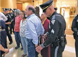  ?? ANDY STINY/THE NEW MEXICAN ?? A state police officer handcuffs Leo Sullivan, a Santa Fe County resident who was among protesters arrested Thursday night after they refused to leave the Capitol.