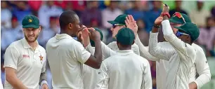 ?? AFP ?? Zimbabwe’s Tendai Chatara (second left) celebrates with his teammates after the dismissal of Bangladesh­i’s Imrul Kayes in the first Test in Sylhet on Sunday. —