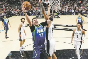  ?? ERIC GAY/ASSOCIATED PRESS FILE PHOTO ?? Mavericks guard Luka Doncic drives to the basket against Spurs center Trey Lyles during a February 2020 game in San Antonio, Texas.