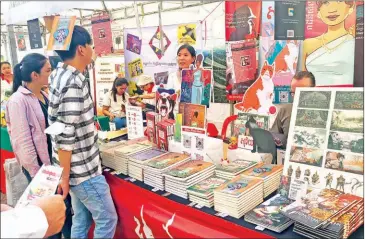  ?? HONG RAKSMEY ?? Eager attendees examine some of the thousands of tomes on display at the 10th Cambodia Book Fair, held at the capital’s Koh Pich from December 14-17.