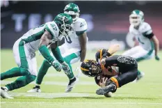  ?? DARRYL DYCK/THE CANADIAN PRESS. ?? The Roughrider­s’ defence made life difficult for B.C. Lions quarterbac­k Travis Lulay, right, on Saturday.